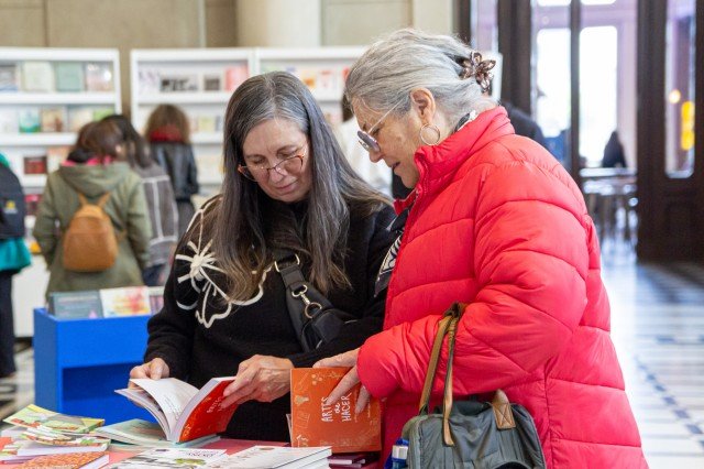 Dos visitantes hojean libros en un stand de la Feria del Libro de Santa Fe