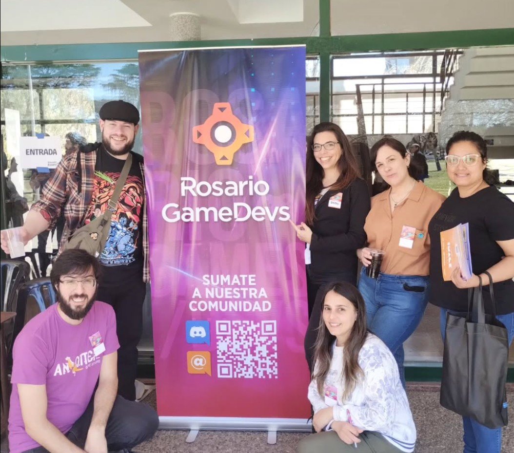 Integrantes de Rosario Game Devs junto al banner de la asociación